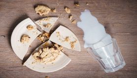 Piatto rotto con cibo e bicchiere di latte rovesciato
