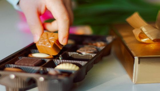 Prendere un cioccolatino da una confezione regalo