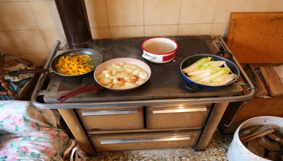 Stufa a legna con diverse pentole in cottura
