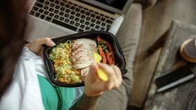 Donna mangia il pranzo portato da casa in ufficio