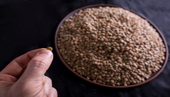 Mano che tiene un granello di lenticchie