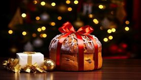 Panettone di Natale con fiocco e luci sullo sfondo