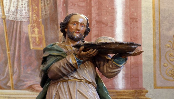Statua di un santo che sorregge un vassoio con cibo