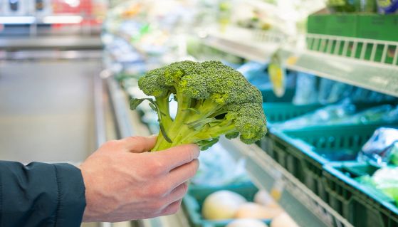 Uomo compra broccoli al supermercato