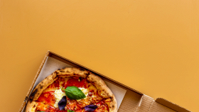 Pizza appena sfornata su tavolo in legno in occasione del World Pizza Day, simbolo della tradizione italiana e del boom del delivery nel Sud Italia