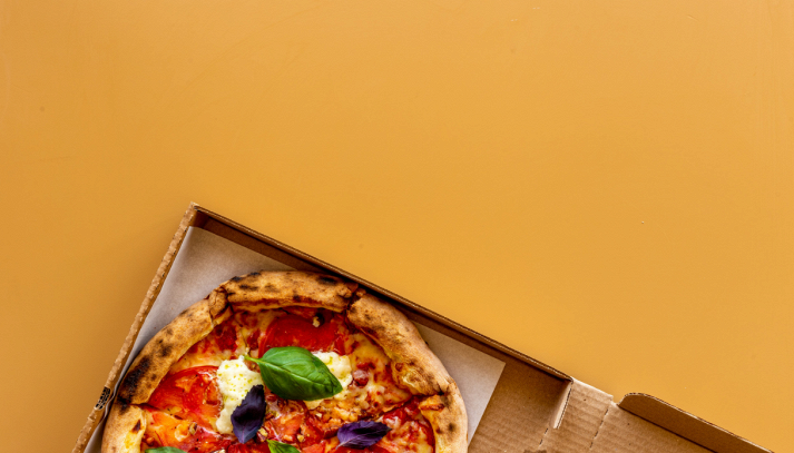 Pizza appena sfornata su tavolo in legno in occasione del World Pizza Day, simbolo della tradizione italiana e del boom del delivery nel Sud Italia