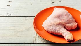 Coscia di pollo cruda su piatto arancione
