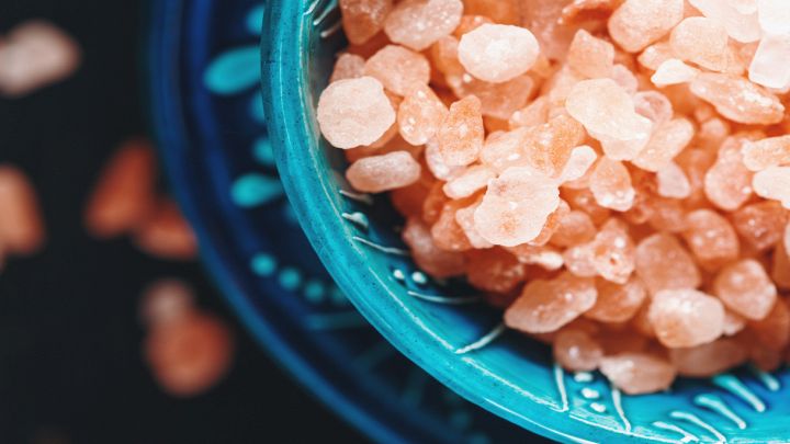 Cristalli rosa di sale dell'Himalaya in una ciotola blu