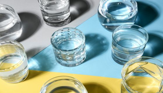 Diversi bicchieri d'acqua su sfondo colorato