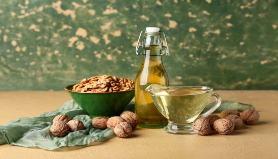 Olio di noci con frutti su sfondo verde