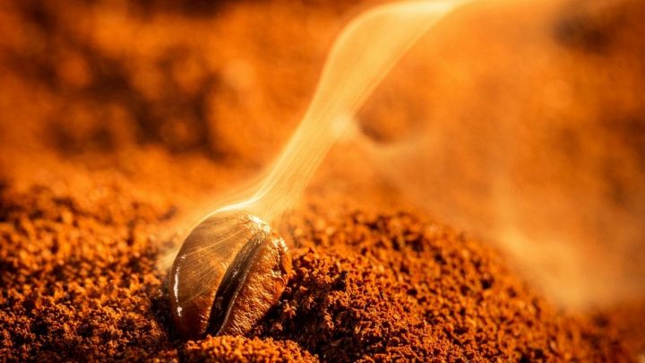 Chicco di caffè fumante, misto a caffè macinato