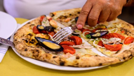 Donna mangia gustosa pizza ai frutti di mare