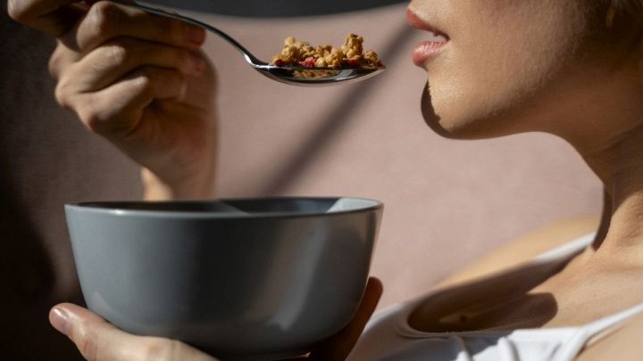 Donna mangia una porzione di fiocchi d'avena