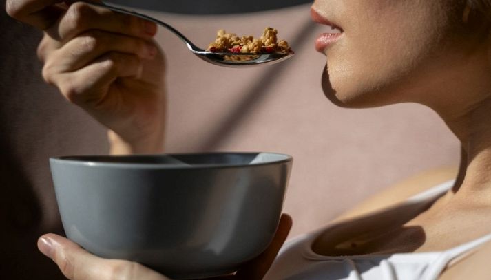 Donna mangia una porzione di fiocchi d'avena