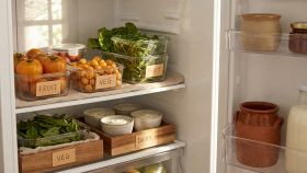 Primo piano di organizer per frigorifero con cibi freschi all'interno, illuminazione naturale e colori caldi.