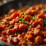 Padella con salsa di pomodoro che cuoce lentamente mentre viene mescolata
