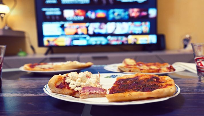 Pizza farcita con televisione accesa sullo sfondo