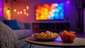 Televisione sullo sfondo con cibo da sgranocchiare in primo piano