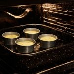 Ungete gli stampini con burro, riempiteli con il composto e sistemateli in una teglia alta. Versate dell’acqua calda nella teglia fino a coprire metà degli stampini. Cuocete in forno statico a 160 °C per circa 35 minuti fino a quando i flan saranno solidificati alla base ma ancora leggermente morbidi al centro.