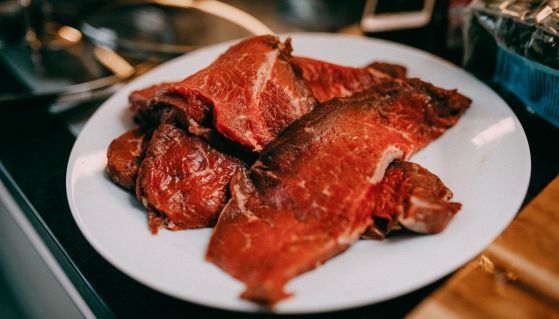 Un piatto in cucina con delle bistecche crude e al sangue