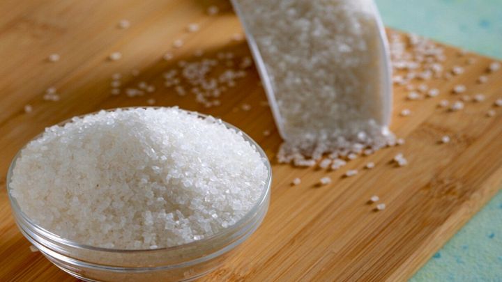 Ciotola con zucchero bianco su tagliere di legno