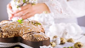 Colomba di Pasqua con mandorle e glassa su sfondo romantico