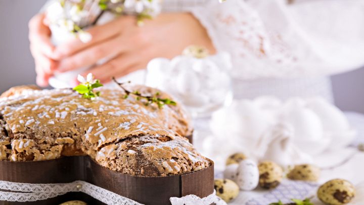 Colomba di Pasqua con mandorle e glassa su sfondo romantico
