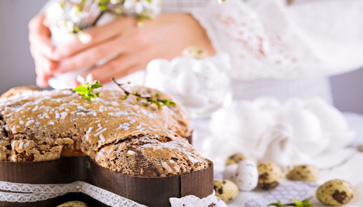 Colomba di Pasqua con mandorle e glassa su sfondo romantico
