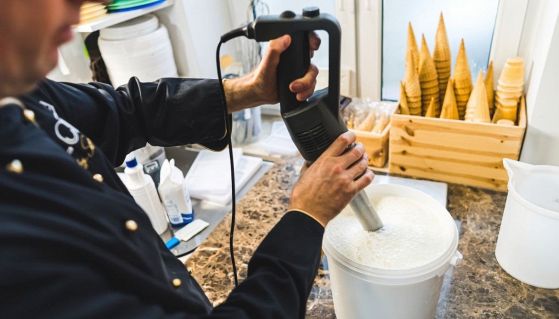 Gelataio che monta la panna in laboratorio