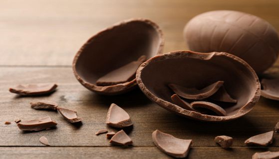 Gustoso uovo di cioccolato rotto e intero su tavolo di legno