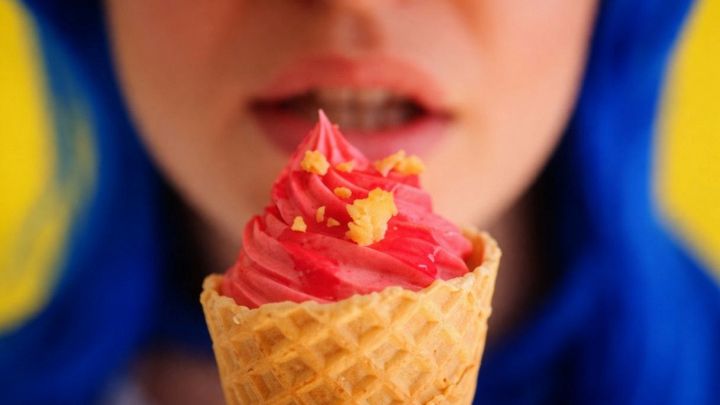 Delle labbra femminili con un cono gelato davanti