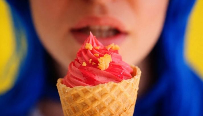 Delle labbra femminili con un cono gelato davanti