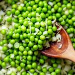 Fave e cipollotti che cuociono insieme in padella