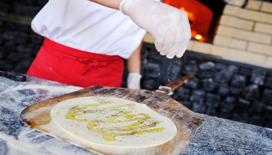 Pizzaiolo prepara una gustosa e croccante focaccia bianca