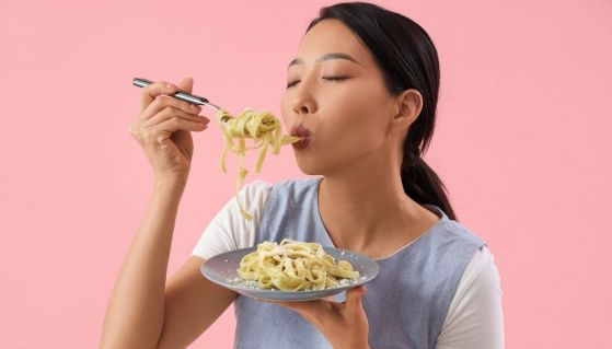 Influencer asiatica mangia un piatto di spaghetti