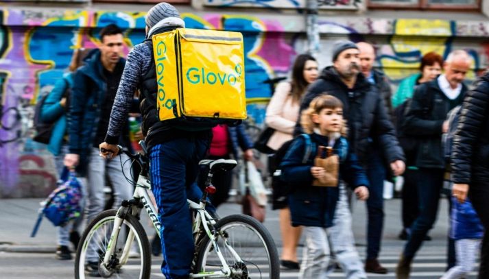 Rider glovo consegna cibo in una scuola