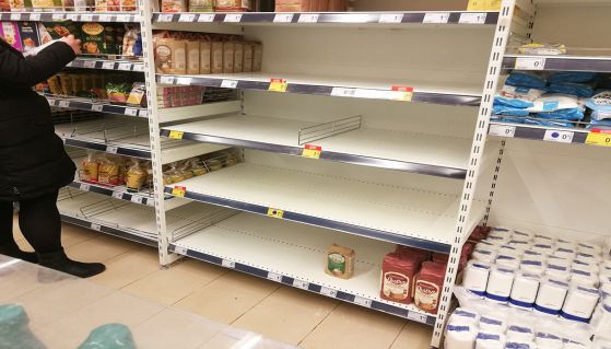 Supermercato con scaffali semivuoti