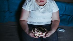 Donna mangia dolci e guarda la tv
