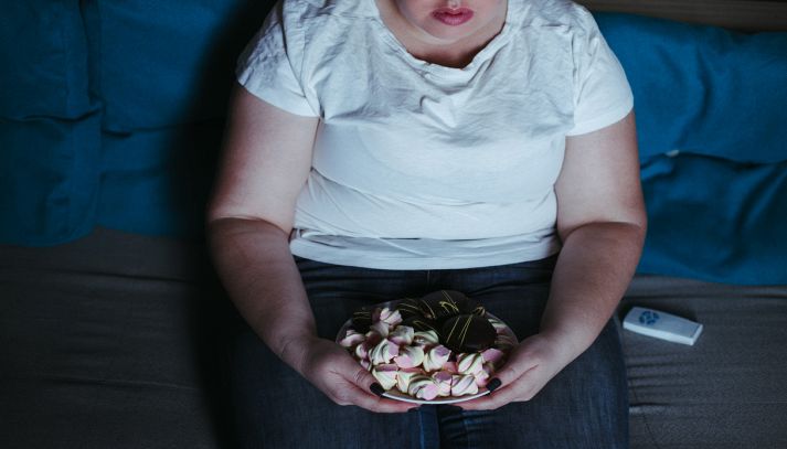 Donna mangia dolci e guarda la tv