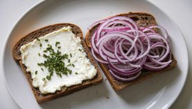 Due fette di pane integrale tostato con spalmabile e cipolla