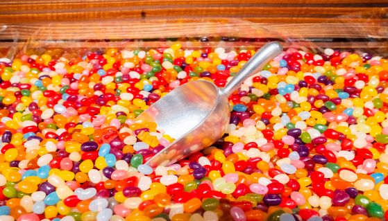 Paletta d'acciaio tuffata in un grande contenitore di caramelle Jelly Beans