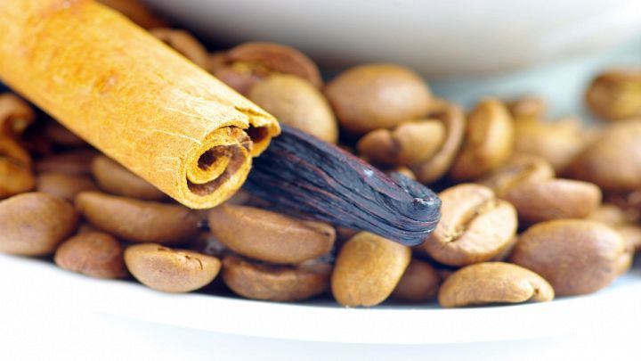 Tazzina con chicchi di caffè, cannella e vaniglia