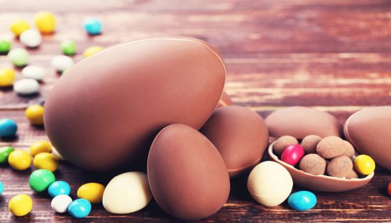 Uova di cioccolato di Pasqua con le caramelle sulla tavola di legno marrone