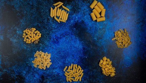 Differenti tipi di pasta italiana su sfondo blu
