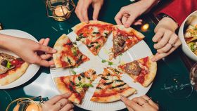 Amici dividono una gustosa pizza farcita