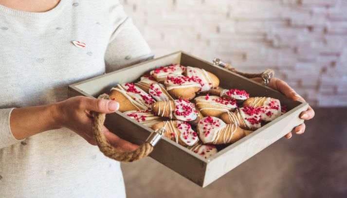 Biscotti fatti in casa a forma di cuore all'interno di un vassoio di legno