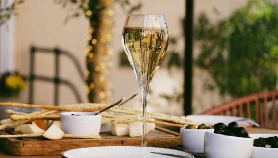 Aperitivo con calice tulipano di prosecco e stuzzichini