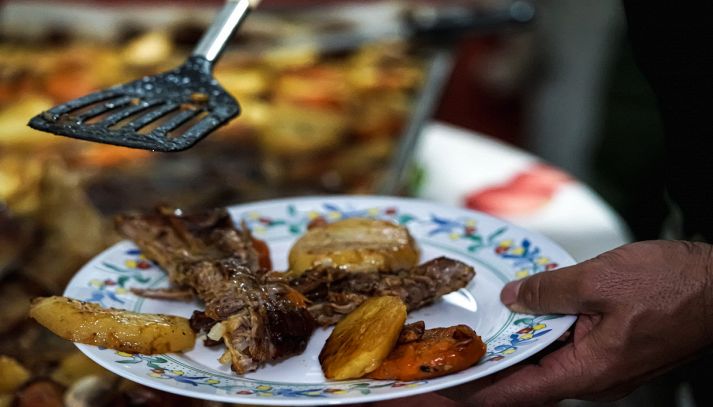 Cameriere impiatta carne croccante e patate al forno