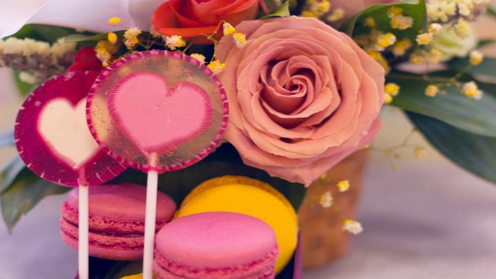 Composizioni festive romantiche con rose, macarons e caramelle