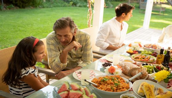 Nonno e nipote parlano durante un pranzo in famiglia